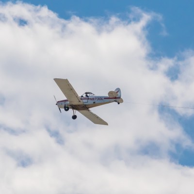 a fighter jet flying through a cloudy blue sky