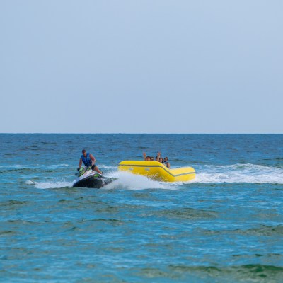 a group of people in a banana boat being pulled by a jet ski